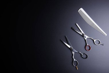 Şık profesyonel kuaför makası ve siyah bac üzerinde beyaz tarak