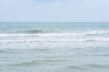 Okyanus dalgaları yorgun sahilde.