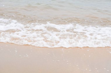 Okyanus dalgaları yorgun sahilde.