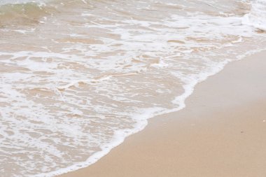 Okyanus dalgaları yorgun sahilde.