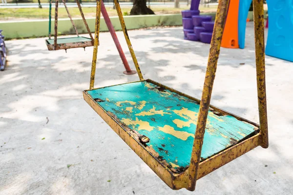 Närbild av färgglada svängningar i lekplats på park. — Stockfoto