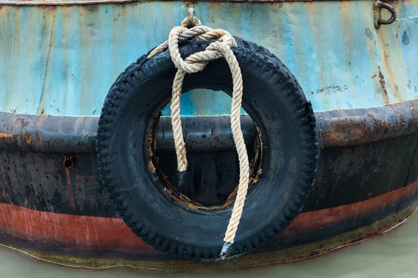Старое резиновое колесо, висящее перед подушкой для корабля . — стоковое фото