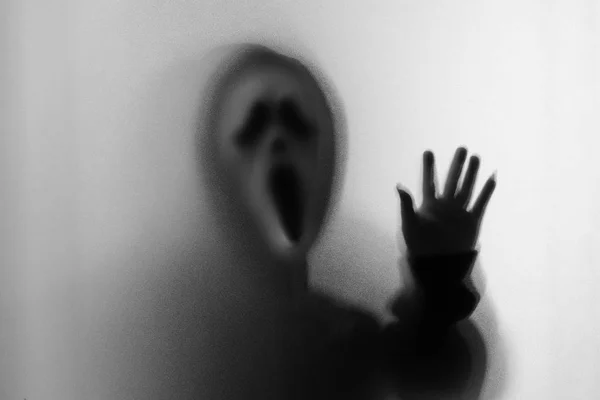 Тень человека ужасов в кричащей маске и руке трогает — стоковое фото