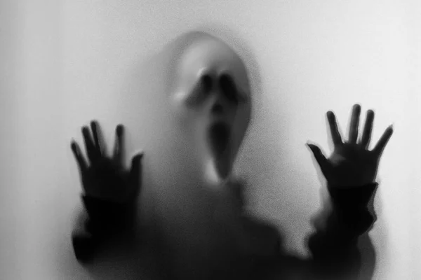 Тінь розмивання жахів людини в кричущій масці і рука торкається — стокове фото