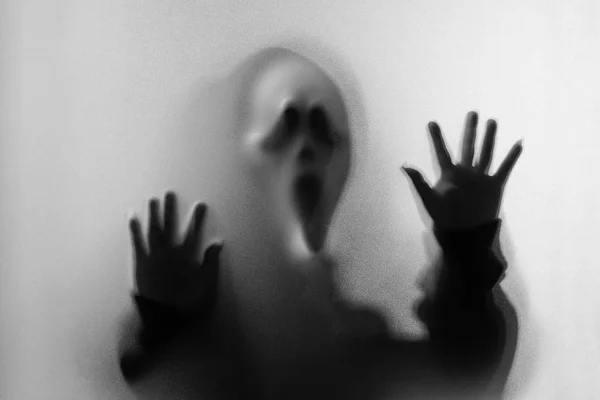 Shadow blur of horror man in screaming mask and hand touches the — Stock Photo, Image