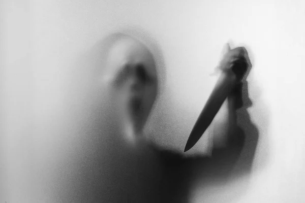 Ombre flou de l'homme d'horreur dans le masque hurlant et montrer couteau dans salut — Photo