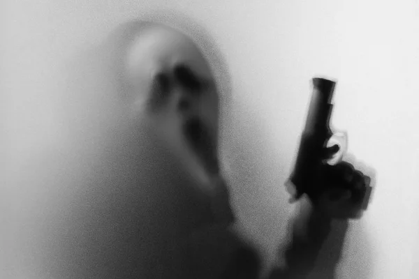 Тіньове розмиття жахів людини кричить маска і показує пістолет в його — стокове фото