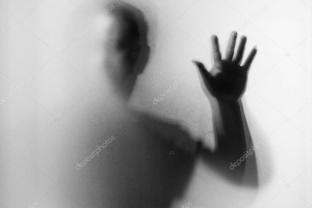 Shadow blur of horror man.Dangerous man behind the frosted glass