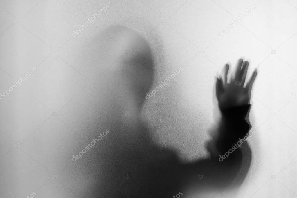 Shadow blur of horror man in screaming mask and hand touches the