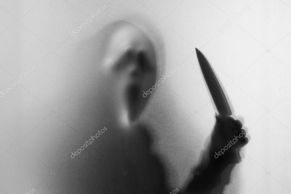 Shadow blur of horror man in screaming mask and show knife in hi