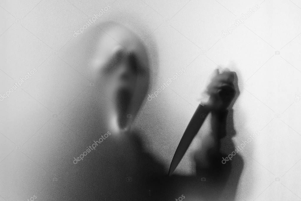 Shadow blur of horror man in screaming mask and show knife in hi