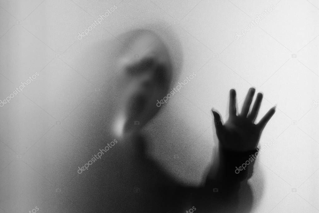 Shadow blur of horror man in screaming mask and hand touches the