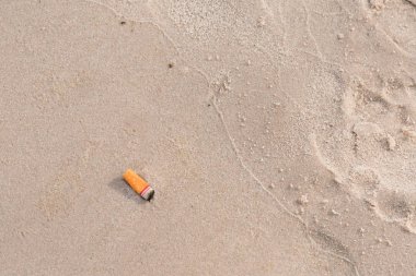 Sigara izmariti kum plaj, kirliliği çöp üzerinde.