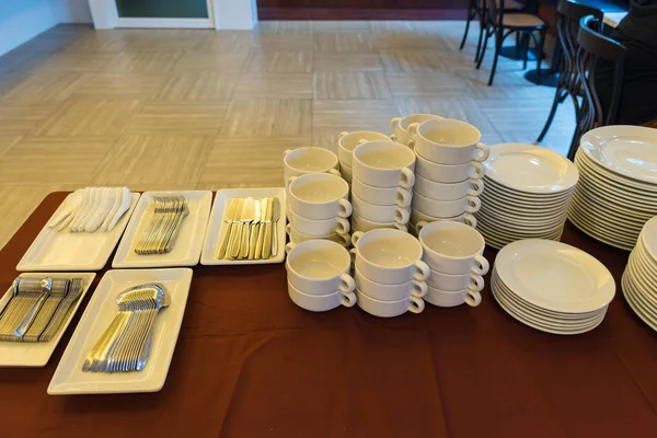 Borden en kommen, witte keramische op een bruin tafellaken. — Stockfoto