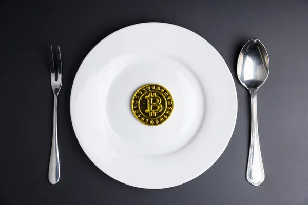 Bitcoin d'oro criptovaluta in piatto bianco su dorso nero — Foto Stock