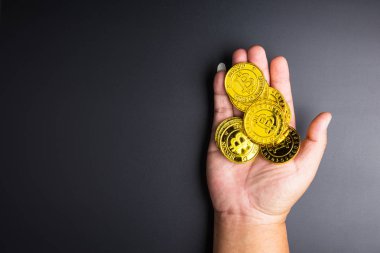 Cryptocurrency altın bitcoins jeton adam el üzerinde siyah backgro
