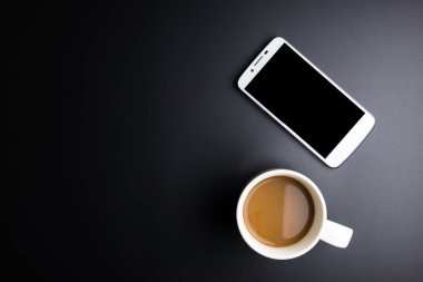 Beyaz kahve fincanı ve smartphone ile siyah arka plan üzerine sp kopyalayın