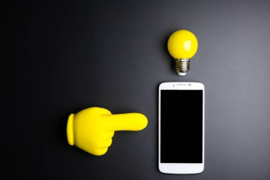 Smartphone ve ampul kopya alanı siyah zemin üzerine.