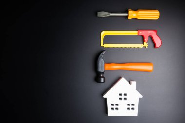 Ahşap beyaz ev ve inşaat araçları oyuncak üzerinde siyah adam