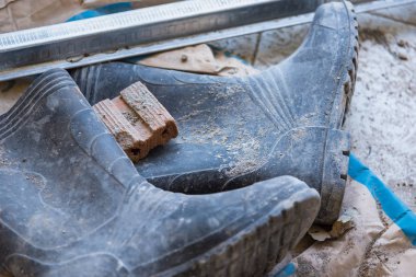 İnşaat alanında çalışan kirli lastik çizmeler..