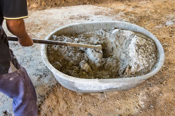 Worker Mixed Cements in Basin Mixer with Hoe in construction sit