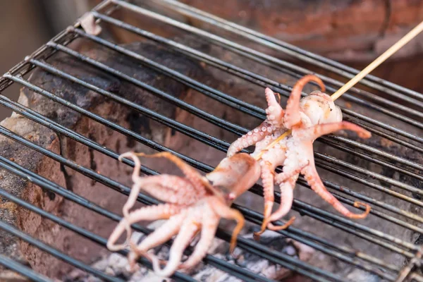Thai street food, grilled squid while grilling on the stove.sele
