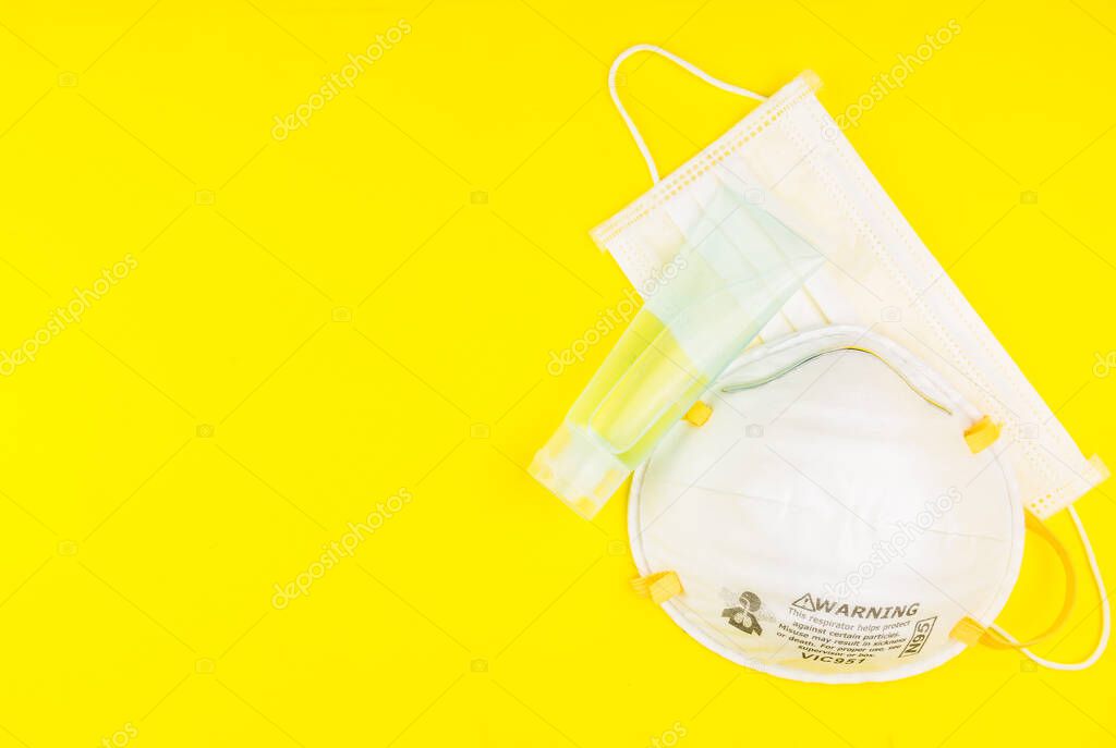 Surgical Face Mask and Alcohol gel to wash hands. Coronavirus Concept. Medical Face Mask For Stopping The Spread of Virus. Surgical mask with rubber ear straps. surgical mask to cover the mouth nose.