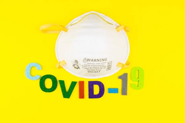 Surgical Face Mask isolated on yellow background. Coronavirus Concept. Medical Face Mask For Stopping The Spread of Virus. Surgical mask with rubber ear straps. surgical mask to cover the mouth nose.