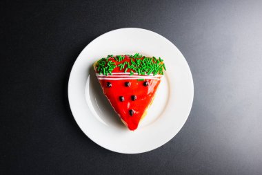 Siyah arkaplanda beyaz bir tabakta meyveli çörek. Mesaj için yer var.