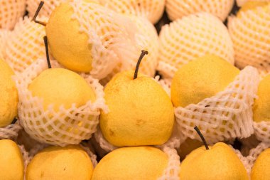 Yerel bir markette birden fazla organik Asya armudunun yakın çekimi. Meyve ve beslenme konsepti.