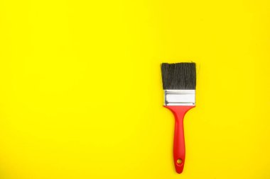 Sarı arkaplandaki boya fırçalarının üst görünümü, kopya alanı, minimalist biçim