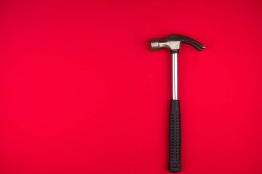 Kırmızı arkaplanda Parlayan Metal çekiç. Üst görüntü. Metin için boşluk