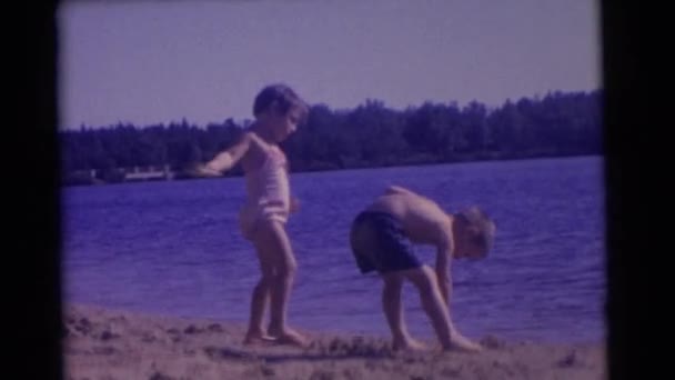 Crianças brincando com areia perto do rio — Vídeo de Stock