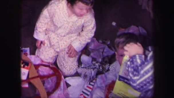 Дети разворачивают подарки — стоковое видео