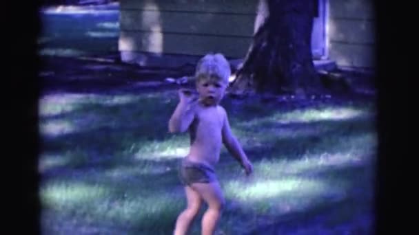Ребенок ходит по заднему двору — стоковое видео