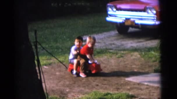Jungen fahren rotes Spielzeugauto — Stockvideo