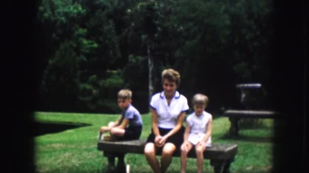 Vrouw met kinderen zitten op bankje — Stockvideo