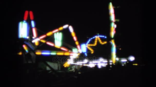 Osvětlené atrakce v zábavním parku v noci — Stock video
