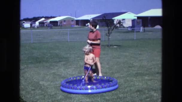 Garçon remplissant la piscine arrière-cour avec de l'eau — Video