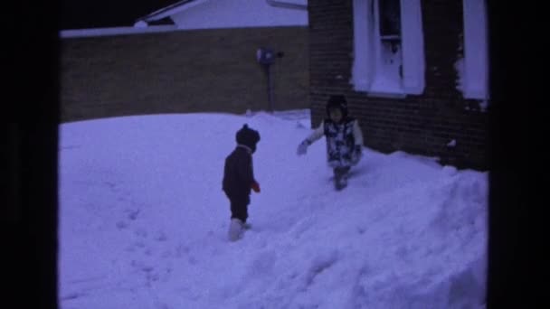 Kids playing in snow near house — Stock Video