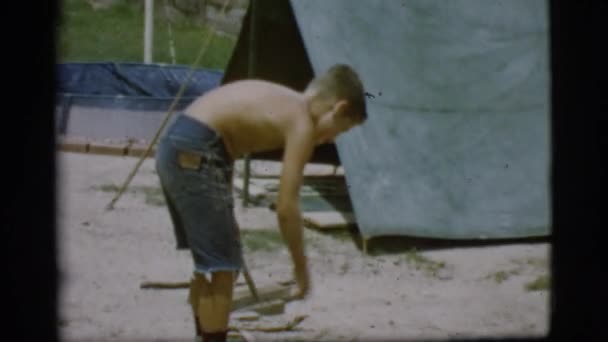 Мальчик разводит костёр — стоковое видео