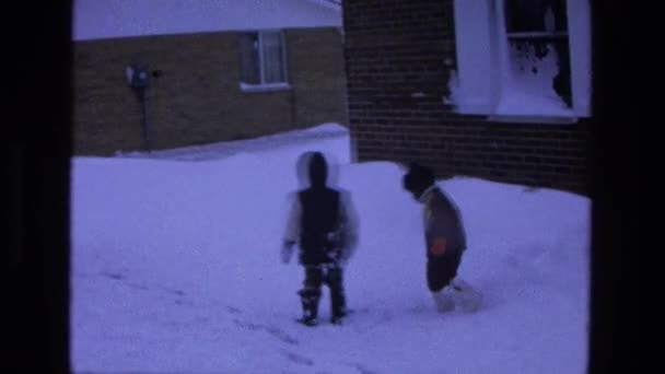 Kids playing in snow near house — Stock Video