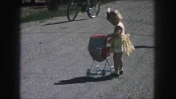 Κορίτσι παίζει με Μωρό καροτσάκι-παιχνίδι — Αρχείο Βίντεο