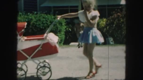 Little girl playing with baby stroller — Stock Video