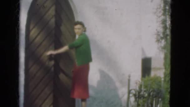 Женщина открывает деревянную дверь — стоковое видео