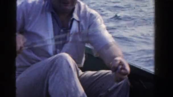 Человек отцепленной рыбы от рыболовных снастей — стоковое видео