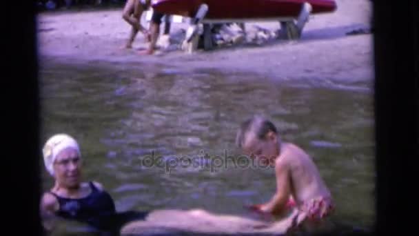 Boy vylévá vodu na ženu v řece — Stock video