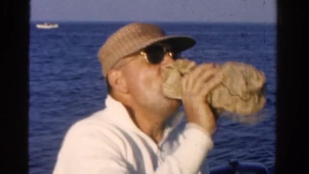 Человек пьет из упаковки пергамента — стоковое видео