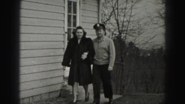 Мужчина и женщина идут рядом с домом — стоковое видео