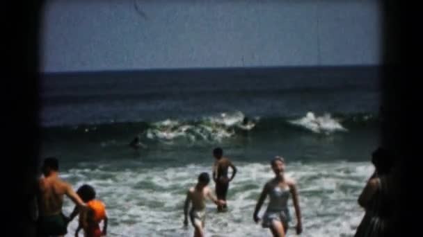 Люди грають з морських хвиль — стокове відео
